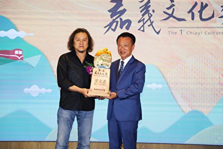 国际地景艺术家王文志（左）荣获第一届嘉义文化奖，由县长翁章梁（右）亲自颁发奖杯及奖励金表扬。