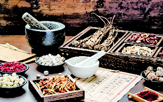 Ancient Chinese medicine books and herbs on the table.English Translation:Traditional Chinese medicine is used in the prevention and treatment of diseases, has the function of rehabilitation.