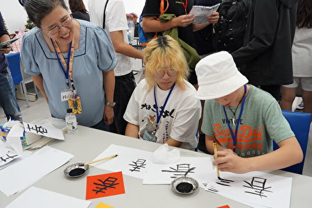 醒吾科大应英系舒海伦老师(左)教导学生写春联，每位学生都认识学习笔画。