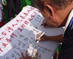 竹山镇公所王秀安主任秘书签名支持营救活动(大纪元摄影)