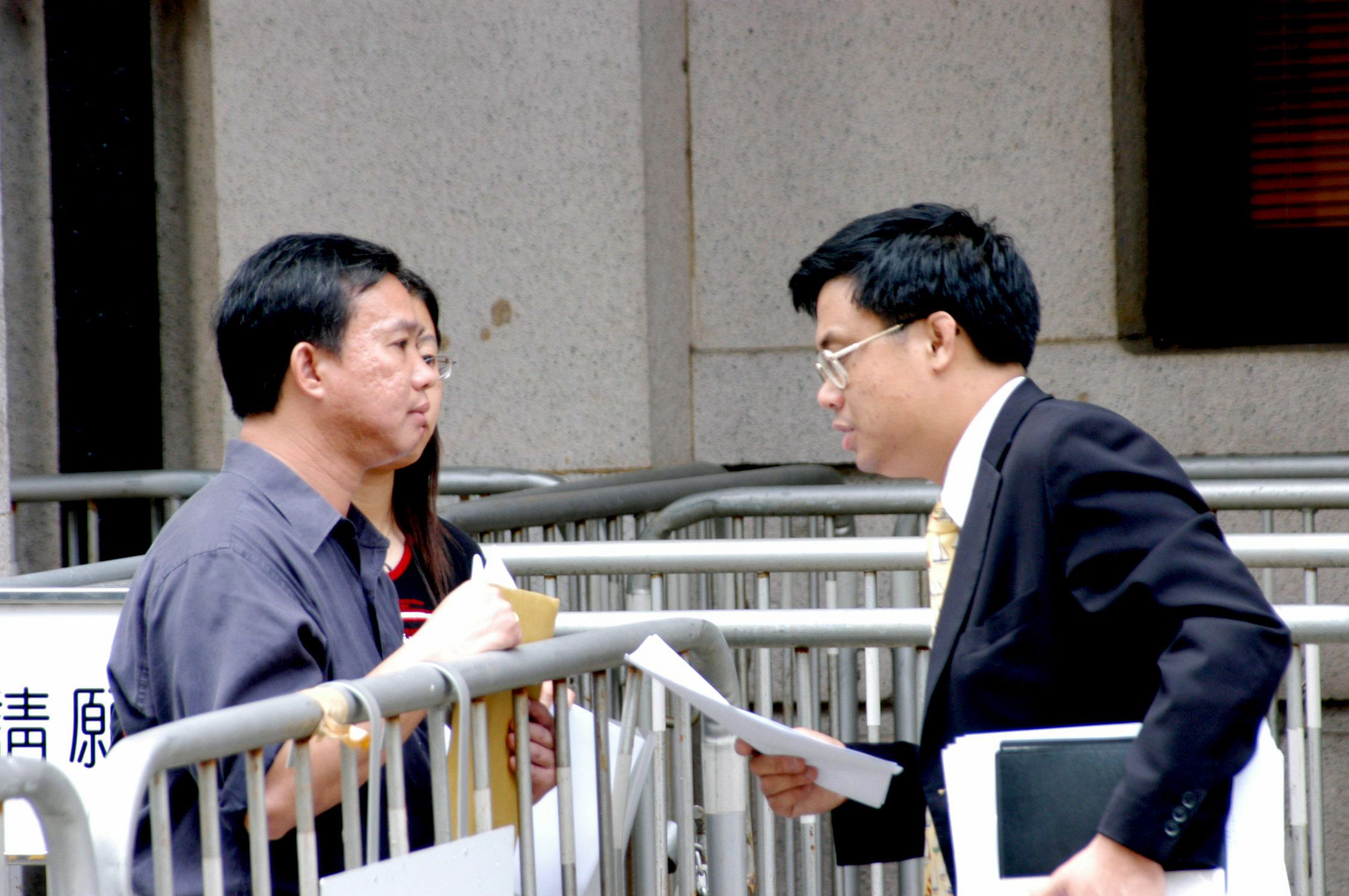 立法會議員涂謹申對傅學英被大陸當局關押表示關注,他接過請願信後,停步向傅的丈夫了解詳情。(大紀元圖片庫)