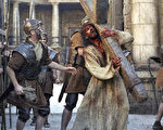 「耶穌受難記」影片中耶穌扛著沉重的厚木十字架。(法新社)