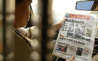 2004年1月6日廣州市民在讀南方都市報。(AFP/Getty Images)
