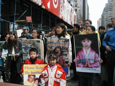 张玉辉的幼儿(左下角)在纽约手举父亲照片呼吁营救。(大纪元图片)