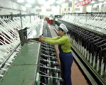 一中國婦女在海南一紡織工廠幹活 (AFP/Getty Images 3/30/2004)