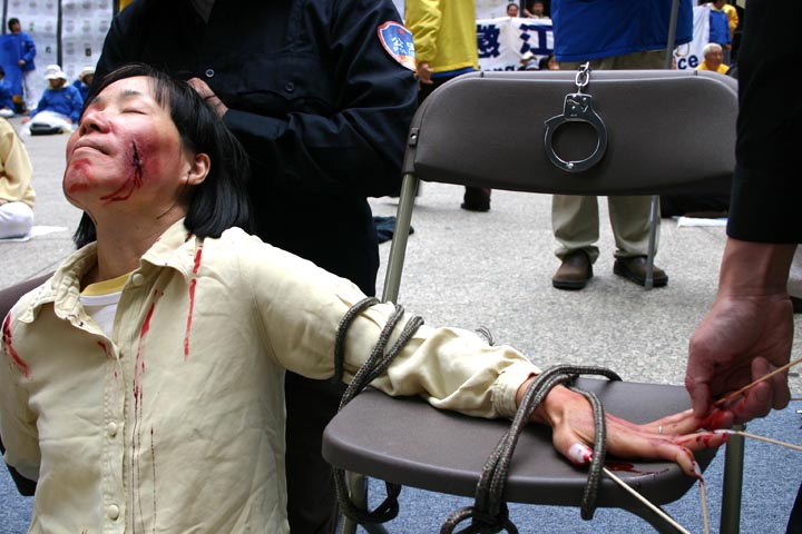 2004年5月,法輪功學員在美國芝加哥以真人、模型演示等形式再現江氏集團迫害法輪功學員的部份酷刑。慘烈的迫害震撼了芝加哥觀眾。圖為酷刑演示:手指釘竹籤。各種令人觸目驚心的酷刑用來逼迫法輪功修煉者放棄信仰。(大紀元資料圖片)