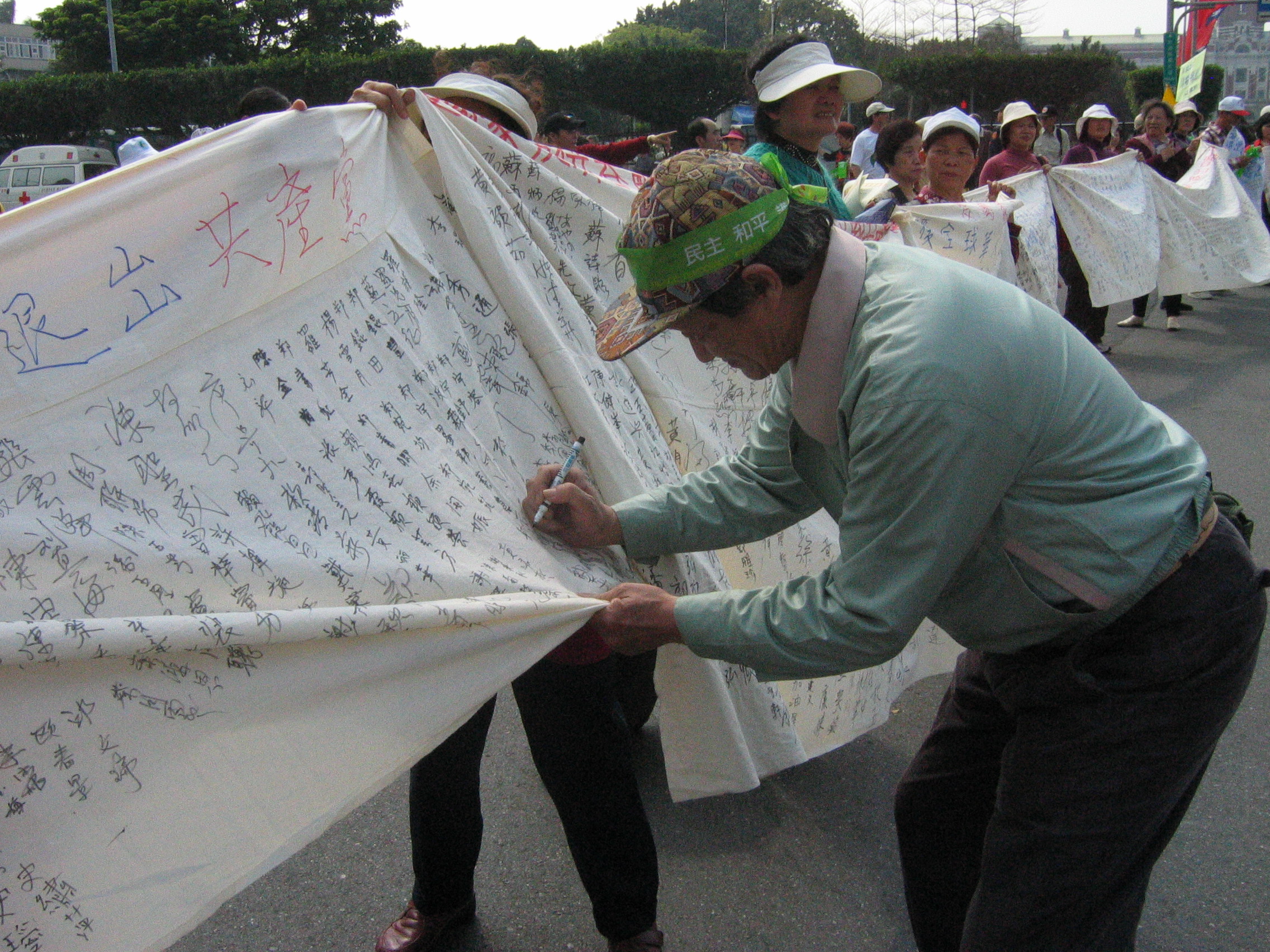 3月20日開始,臺灣民眾發起簽名聲援全球華人退出中國共產黨的活動,迄今,聲援中共退黨簽名人數超過30萬人簽名。圖為臺北民眾簽名聲援退黨。大紀元新聞圖片。