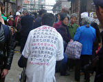 圖：北京信訪辦門口等待上訪的民衆，一上訪者背上寫滿對官員腐敗的聲討檄文（大紀元）