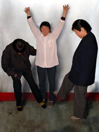 背貼在牆上,腳尖著地雙手上舉貼在牆上,稍一貼不住或站不住,勞教犯就用腳(穿硬塑料半高跟鞋)踢迎風骨,很多半年雙腳才恢復原樣。