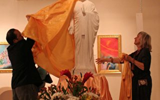 加拿大法轮大法学会会长李迅先生和画家凯瑟琳·吉里丝女士为雕塑“佛像”揭幕(大纪元)