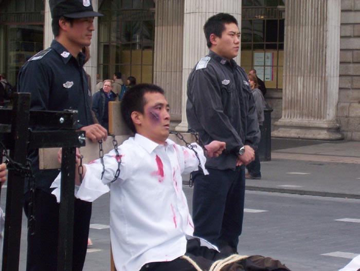 原清華紫光集團經理趙明,曾在北京新安勞教所被警察用六根幾萬伏電棍電擊,每天強迫罰站二十多個小時,或軍蹲十多小時,雙腿劇疼無比。圖為趙明在愛爾蘭酷刑演示中模擬老虎凳酷刑。(大紀元)