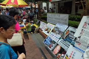 新加坡大紀元義工冒雨在鬧市區徵簽