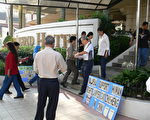 法輪功學員於2006年3月18日在馬來西亞律師公會一年一度的常年大會會場外派發資料。（大紀元）