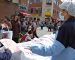 加拿大蒙特利尔唐人街4月9日展示真人演示的法轮功学员被活体摘取器官后贩卖的暴行（大纪元新闻图片）