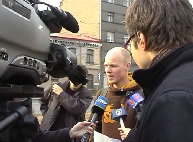 2006年4月14日，拉脱维亚法部分法轮功学员在中共驻里加使馆前开始进行72小时的绝食，抗议中共活摘法轮功学员器官。意大利都灵冬季奥运会铜牌得主卢比尼斯参加了绝食活动。当天拉脱维亚多家主流媒体对此进行了详细报导，图为主流媒体在采访卢比尼斯。（大纪元）