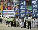 上10名香港民主人士及200多名法轮功学员17日在中环遮打花园参加悼念集会，随后游行到西区中联办抗议中共群体灭绝法轮功学员的暴行。图为游行队伍经过西环。（大纪元记者潘璟桥摄）