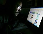 被判７年徒刑的网路作家郑贻春的弟弟在看一网站上郑贻春的照片。（2005年11月法新社照片）