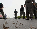 泰國南部士兵清除一條佈滿釘子的道路。(MUHAMMAD SABRI/AFP/Getty Images，2006 年10月17 日)