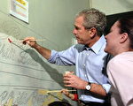 总统布什为纪念纪马丁.路德.金来到卡多索高中做义工。(Photo by Kevin Dietsch-Pool/Getty Images)