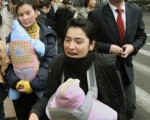 中國上海，二名從新疆來的婦女背著嬰兒參觀。由於「一胎化政策」中國正面臨人口性別不平衡狀態。(Photo credit should read MARK RALSTON/AFP/Getty Images)