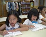 一群二至五岁的小娃儿，正聚精会神的指著书上的字，一字一句的念著《洪吟》