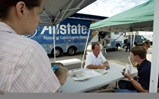 2004年9月20日，Allstate保险公司理赔员正在佛州的PENSACOLA和一个Ivan飓风受灾户商谈赔偿事宜。（Scott Olson/Getty Images）