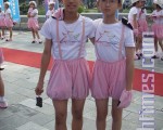 两位身穿大会吉祥物可爱的粉红猪装的后甲国中男生。(摄影：杨逸帆/大纪元)