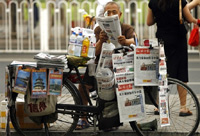 一位小贩在北京街上售报 （法新社）
