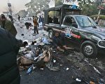 暗殺貝娜齊爾槍手槍傷她後，引爆身上的炸彈，造成最少20人死亡。圖為一名受傷警察倚靠在車旁，等候救援。（AFP）