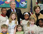 布什总统对一群不同种族儿童讲解马丁.路德.金生平和政治遗产特殊意义。 (Photo credit should read SAUL LOEB/AFP/Getty Images)