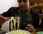 图为一名伊拉克人正在品尝中国面食。（Wathiq Khuzaie/Getty Images）