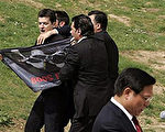 中国奥组委主席刘淇在圣火仪式上致词时，无国界记者组织咨询主任祖烈德在他的身后挥舞黑色上有手铐型五环的旗帜（法新社）