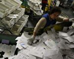美国加州旧金山邮局的邮务人员4月15日过滤了一叠叠的信件，正在加紧赶工处理2300多万封的退税信件，希望能在午夜的最后期限之间，为那些申请退税的民众完成领回退税金额的手续。（Justin Sullivan/Getty Images）
