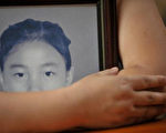 一位失去14歲學生的母親手捧孩子遺像（6月4日法新社）