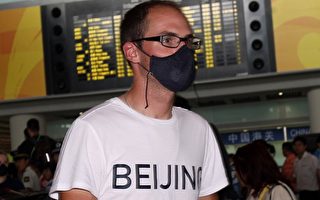 美國運動員戴著口罩抵達北京機場