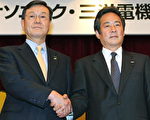 日本Panasoni(左)、三洋电机(右)代表，19日在收购达成协议后，同时召开记者会。 (STR/AFP/Getty Images)