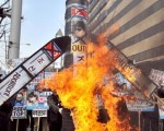 韩国示威群众焚烧朝鲜领袖金正日的照片、朝鲜国旗和一些由纸板做成导弹。(JUNG YEON-JE/AFP/Getty Images)