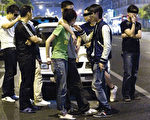 杭州撞人事件后，肇事者同伴在街头有恃无恐地说笑。（大纪元资料图片）