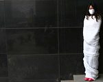 北京一位女子全身被白布包裹，面带口罩，表达对邓玉娇的支持。（法新社）