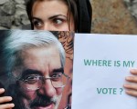 图示一名伊朗穆萨维的支持者举著牌子表示对选举结果的抗议     图片来源：Getty Images