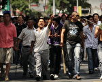 7月7日，一群手持棍棒、铁锹的汉人在新疆乌鲁木齐街道上。（法新社）