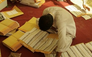 阿富汗的独立选举委员会官员和国际观察员团体正要求公众、媒体和候选人耐心等待官方结果。图为8月21日，阿富汗首都喀布尔一处投票中心，工作人员正在计票。(AFP)