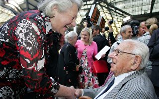 9月4日，近百歲高齡的溫頓爵士（右）在倫敦，利物浦街火車站與70年前669名中的20多名被他救出來的猶太人相聚。圖為溫頓爵士與其中的一位握手。（AFP PHOTO/Geoff Caddick）