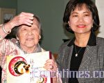 101岁的黄皎莲(左)欢喜接受洪慧珠处长致赠的月饼。(摄影:苏仪/大纪元)