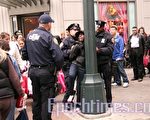 圖：27日上午11點50分左右，在34街先驅廣場(Herald Square)「維多利亞的祕密」商店門口，一位年輕黑人女子涉嫌偷盜被兩名男警察抓獲，反手背銬，等待警車到達。（攝影：余曉∕大紀元）