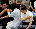 香港行政长官曾荫权(右一)和食物及卫生局长周一岳(左一)等官员，昨日到官方的门诊诊所接种甲型H1N1流感疫苗。（摄影：潘在殊／大纪元）