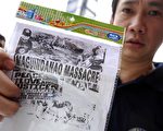 图为菲律宾马吉丹奥省发生震惊全球的政治屠杀案后，全国新闻俱乐部（全国）总裁手持没收盗版 DVD。(NOEL CELIS/AFP/Getty Images)