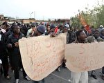 2010年1月8日，意大利羅薩諾鎮種族暴力衝突，昨天移民工人舉著抗議標語牌示威。（圖片來源：AFP）