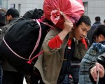 2月6日，北京火車站的民工攜帶行李渴望回家鄉過年。據政府估計，新年期間約有2.4億人次在中國的交通線上。（AFP)