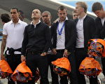表情明顯沮喪的荷蘭隊球員身穿黑色長褲，白色襯衫，手上拿著橘色的花束。(法新社)